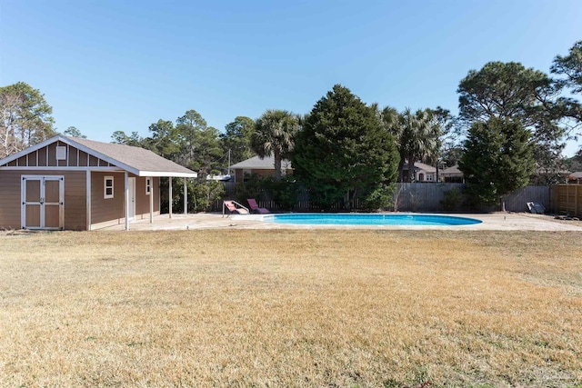 view of swimming pool featuring an outbuilding, a fenced in pool, fence, and a lawn