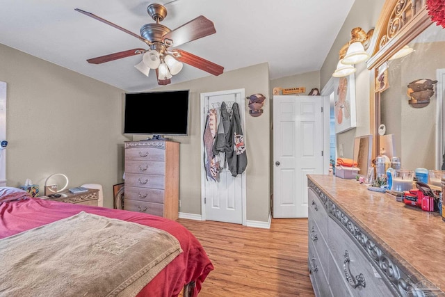 bedroom with light hardwood / wood-style floors, lofted ceiling, ceiling fan, and a closet