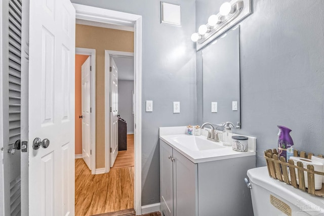 bathroom featuring vanity, hardwood / wood-style flooring, and toilet