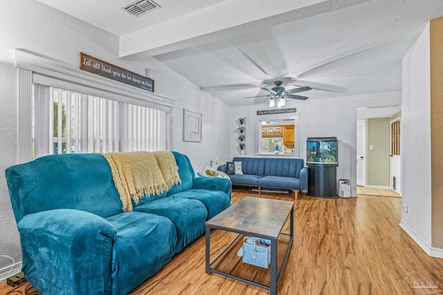 living room with hardwood / wood-style flooring, lofted ceiling with beams, and ceiling fan