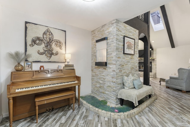 living area featuring wood-type flooring and lofted ceiling with beams