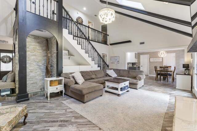 living room featuring a notable chandelier, beam ceiling, hardwood / wood-style floors, and high vaulted ceiling