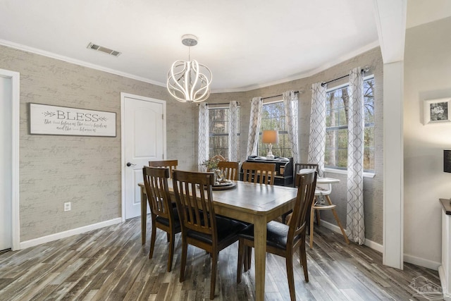 dining area with an inviting chandelier, ornamental molding, and dark hardwood / wood-style flooring