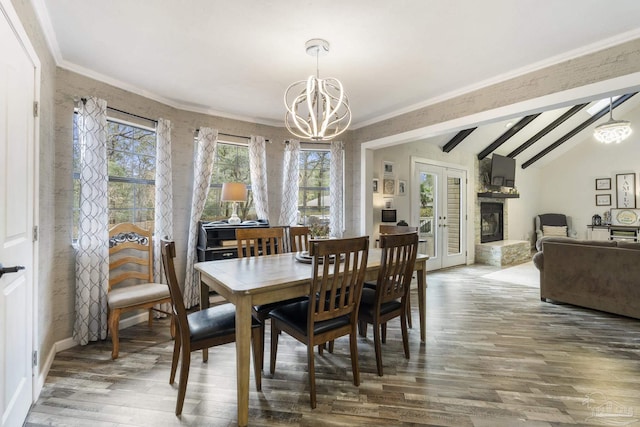 dining room with plenty of natural light, vaulted ceiling with beams, a chandelier, and french doors