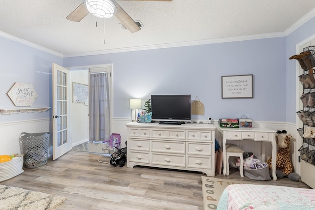 bedroom with crown molding, light wood-type flooring, ceiling fan, and a textured ceiling