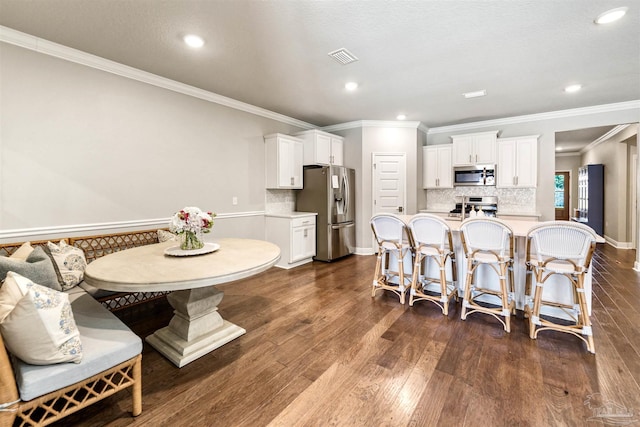 7956 Huntington Creek Ln, Pensacola, FL 32526 - dining room featuring dark wood finished floors, ornamental molding, visible vents, and recessed lighting