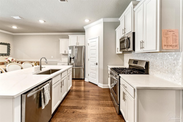 7956 Huntington Creek Ln, Pensacola, FL 32526 - kitchen with tasteful backsplash, ornamental molding, a kitchen island with sink, a sink, and stainless steel appliances