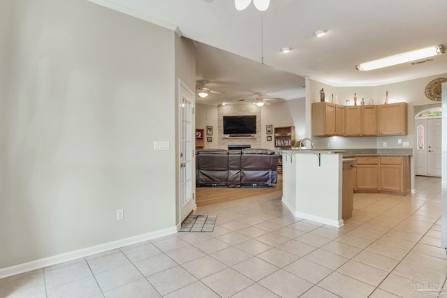 kitchen with light tile patterned flooring, light brown cabinetry, and a breakfast bar