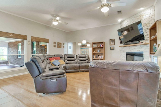 living room with ceiling fan, a fireplace, crown molding, and light hardwood / wood-style floors