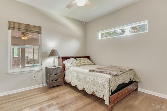 bedroom with ceiling fan, light wood-type flooring, and multiple windows