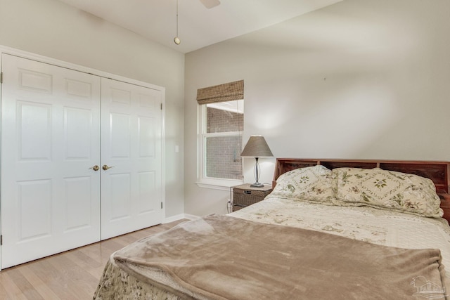 bedroom with ceiling fan, a closet, and wood-type flooring