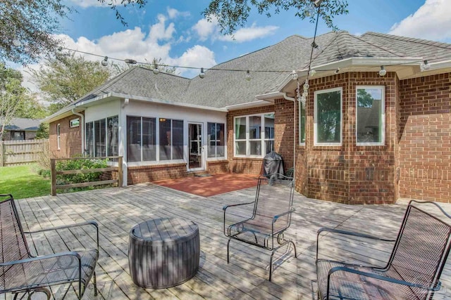 back of property featuring a sunroom and a wooden deck