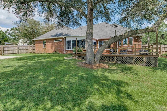 rear view of house featuring a yard and a deck