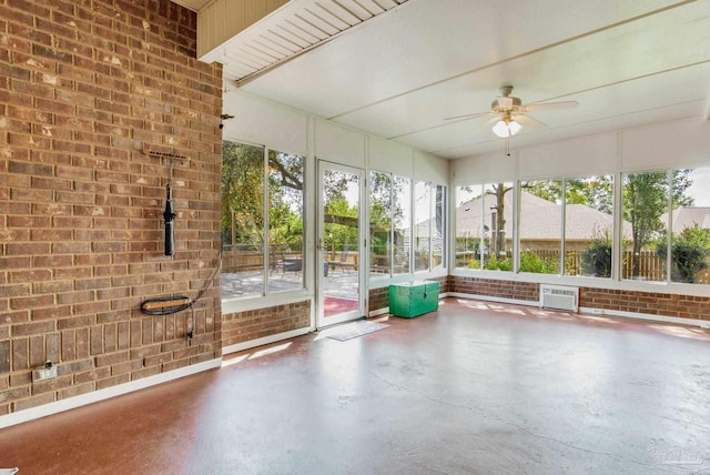 unfurnished sunroom featuring ceiling fan and a wall mounted air conditioner