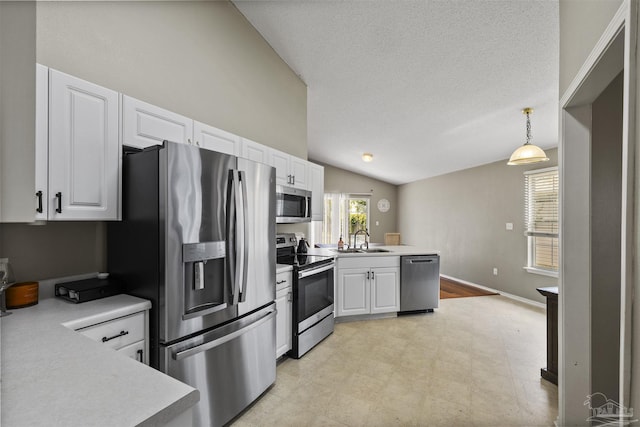 8187 Lode Star Ave, Pensacola, FL 32514 - kitchen with appliances with stainless steel finishes, a sink, a peninsula, vaulted ceiling, and white cabinets