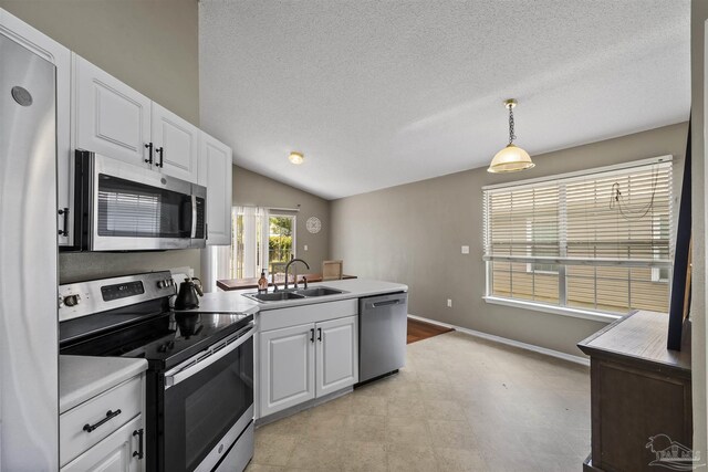 8187 Lode Star Ave, Pensacola, FL 32514 - kitchen with stainless steel appliances, a sink, a peninsula, white cabinetry, and lofted ceiling