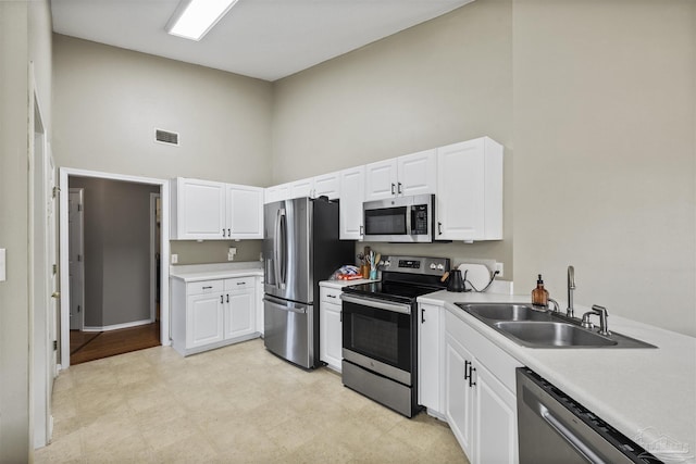 8187 Lode Star Ave, Pensacola, FL 32514 - kitchen with stainless steel appliances, high vaulted ceiling, a sink, white cabinets, and light countertops