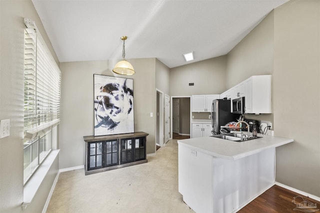 8187 Lode Star Ave, Pensacola, FL 32514 - kitchen with stainless steel appliances, white cabinetry, baseboards, a peninsula, and high vaulted ceiling