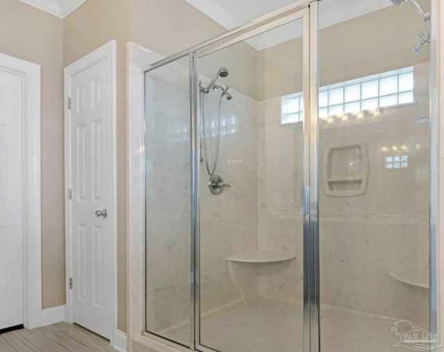 bathroom with an enclosed shower and ornamental molding