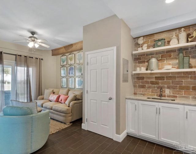 living room featuring electric panel, ceiling fan, and sink