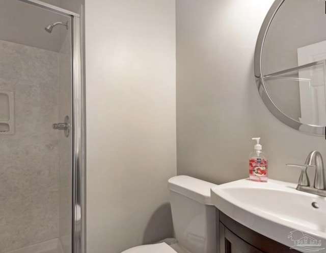 bathroom featuring vanity, an enclosed shower, and toilet