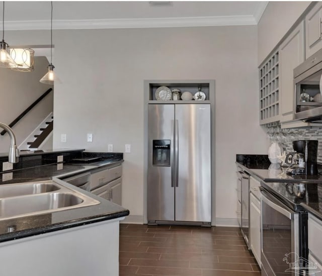 kitchen with pendant lighting, white cabinets, sink, ornamental molding, and appliances with stainless steel finishes