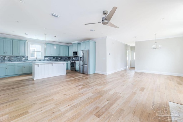 kitchen featuring crown molding, stainless steel appliances, a center island, decorative light fixtures, and light wood-type flooring