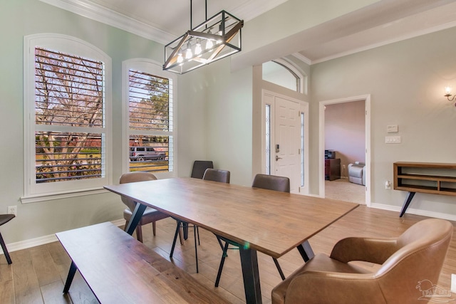 dining room featuring crown molding and light hardwood / wood-style flooring