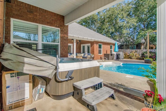 view of swimming pool with a patio and a hot tub