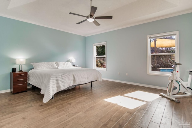 bedroom with ceiling fan, ornamental molding, and light hardwood / wood-style flooring