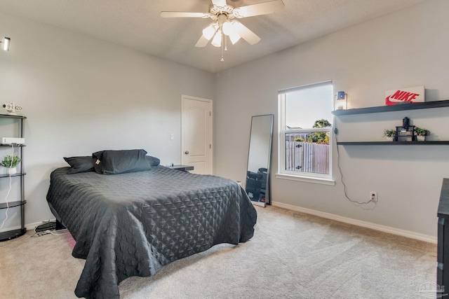 carpeted bedroom featuring ceiling fan and a textured ceiling