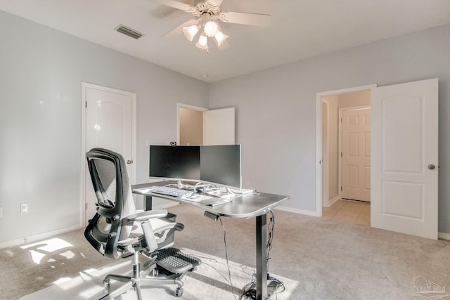 carpeted home office featuring ceiling fan