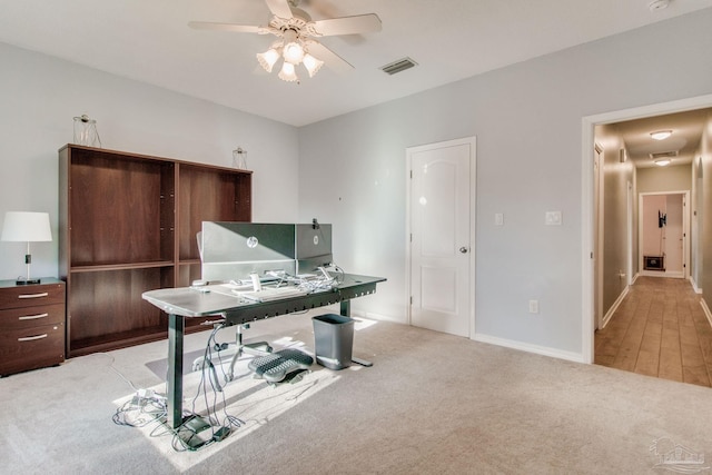 carpeted office featuring ceiling fan