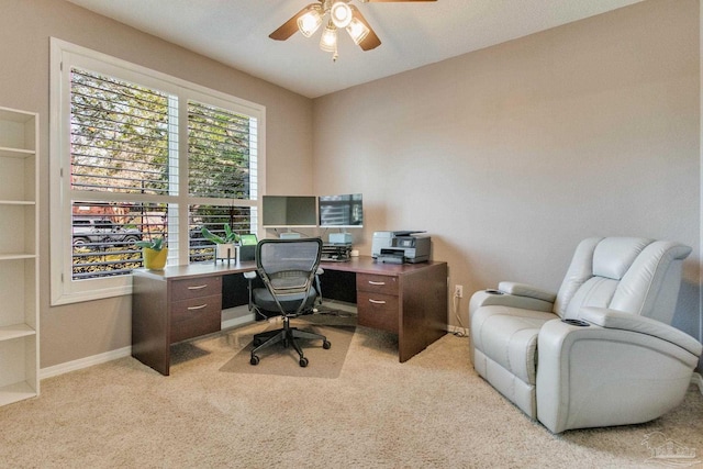 carpeted home office featuring ceiling fan