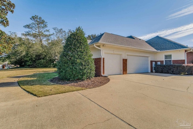 view of side of home featuring a lawn and a garage