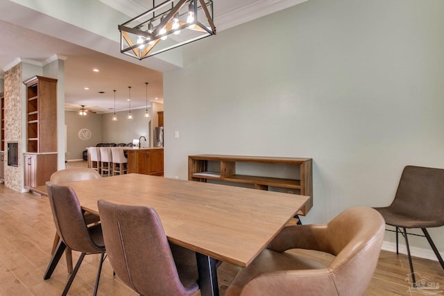 dining space featuring light hardwood / wood-style floors, ceiling fan, and ornamental molding