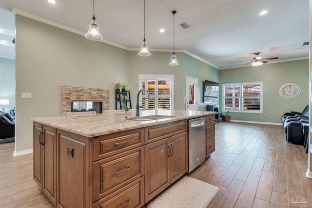 kitchen with an island with sink, light hardwood / wood-style floors, hanging light fixtures, and sink