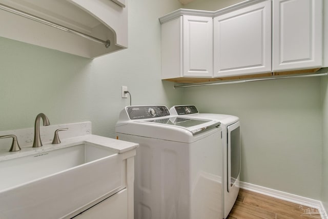 laundry room with washer and dryer, cabinets, and sink