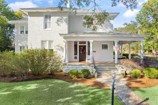 view of front of property with covered porch and a front lawn