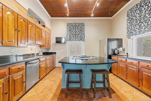 kitchen with a kitchen bar, appliances with stainless steel finishes, a kitchen island, and wooden ceiling