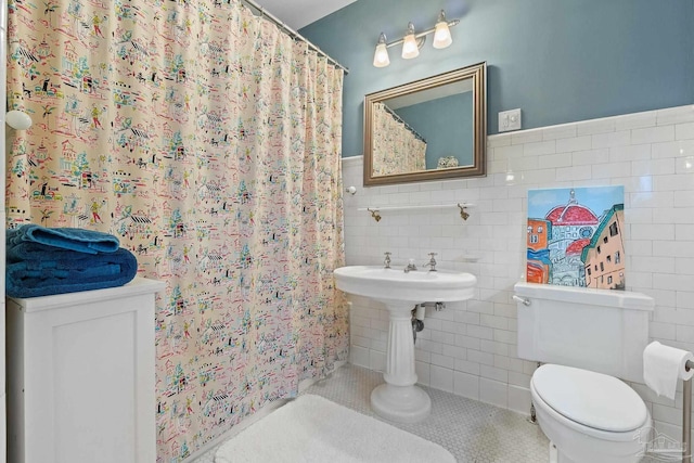 bathroom with tile walls, tasteful backsplash, toilet, and tile patterned flooring