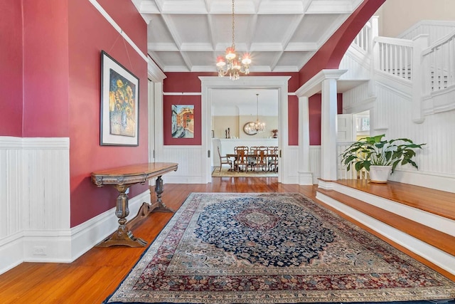 hallway featuring beamed ceiling, a notable chandelier, coffered ceiling, and hardwood / wood-style flooring