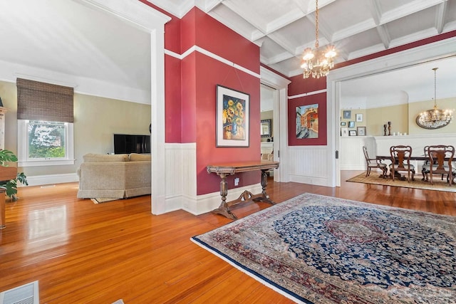 entrance foyer featuring beam ceiling, a notable chandelier, coffered ceiling, and hardwood / wood-style floors