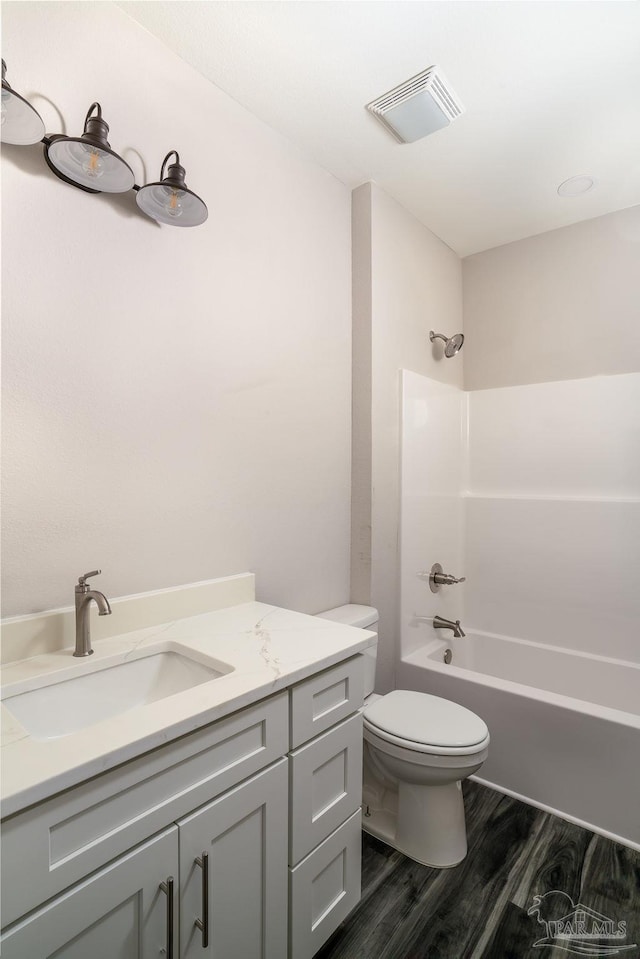 full bathroom with bathing tub / shower combination, vanity, wood-type flooring, and toilet