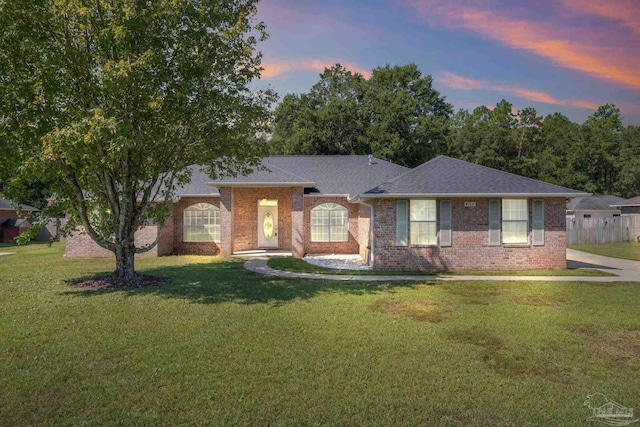 ranch-style home featuring a lawn