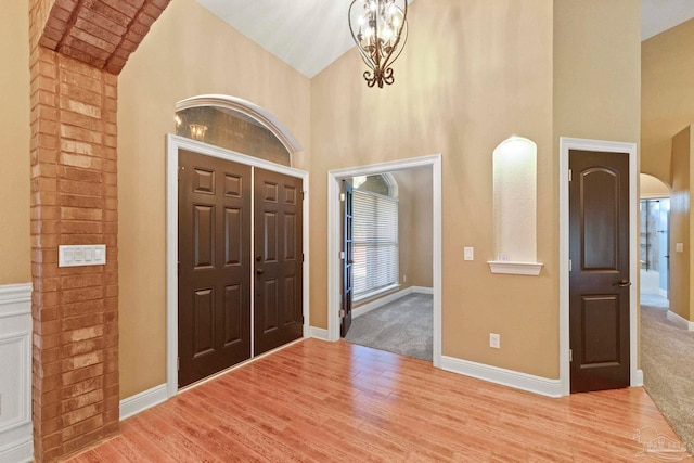 entrance foyer featuring light hardwood / wood-style flooring and high vaulted ceiling