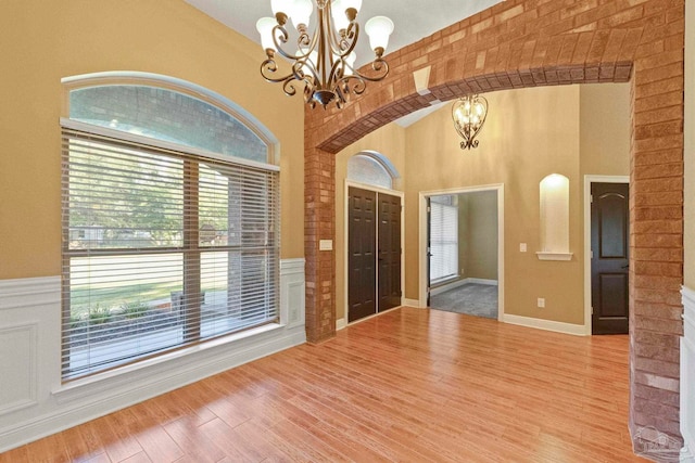 entryway featuring a chandelier, hardwood / wood-style floors, and a high ceiling