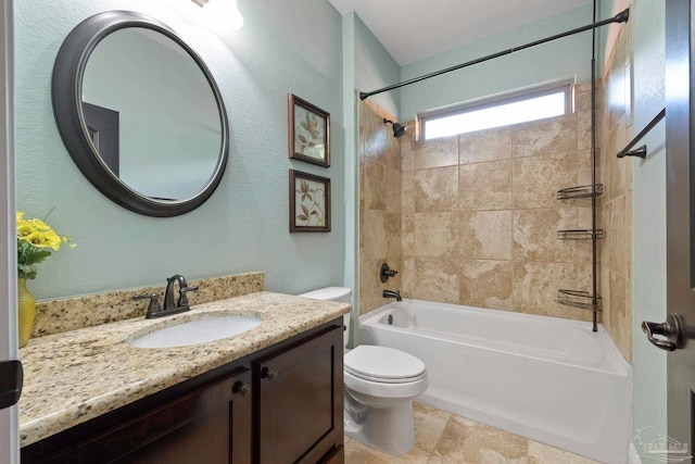 full bathroom featuring tiled shower / bath combo, vanity, and toilet