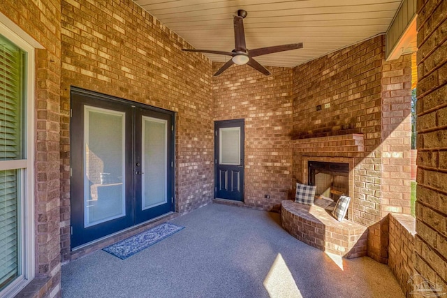 property entrance featuring ceiling fan, an outdoor brick fireplace, french doors, and a patio