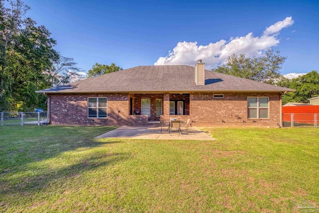 rear view of property with a lawn and a patio area